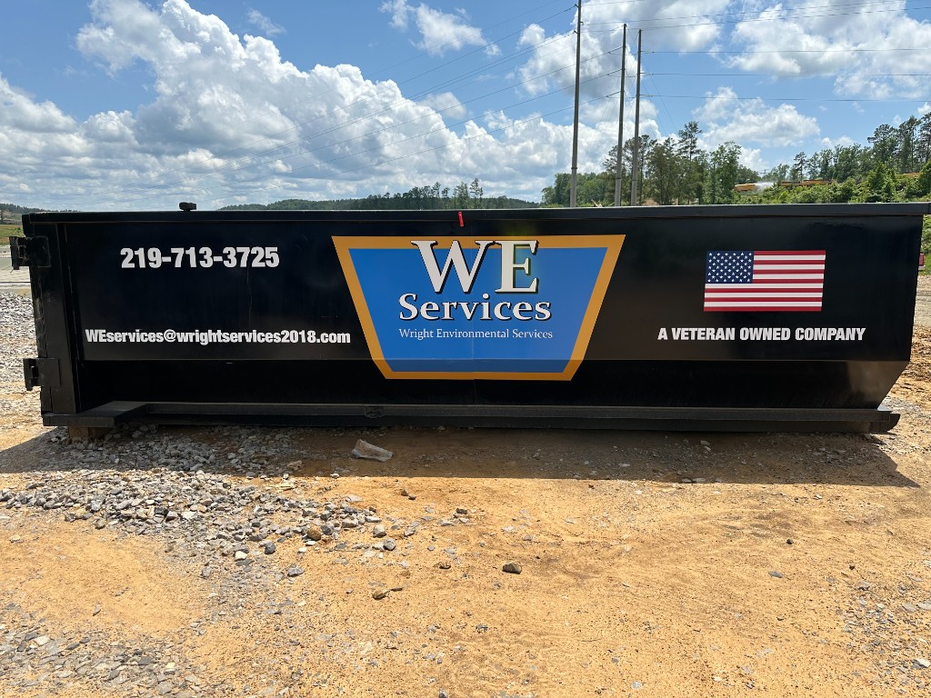 WE Services branded roll-off container with company logo and American flag